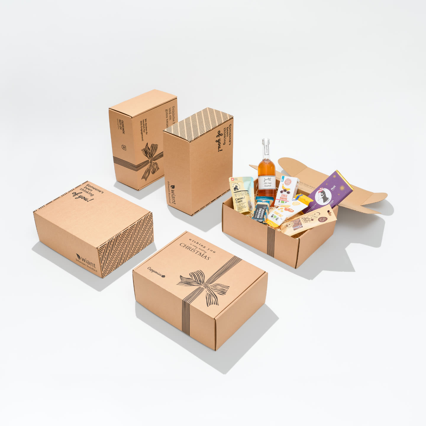 Individuell bedruckte wiant Geschenkboxen mit Firmenlogos, eine Box offen mit Schweizer Produkten